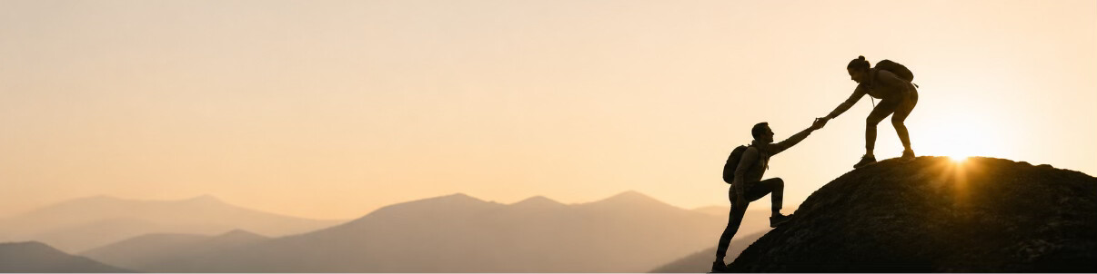 Two people reaching for each other against a sunlit mountain horizon